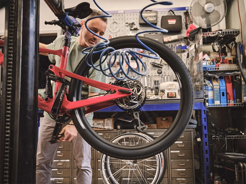 Ein Fachhändler überprüft den Reifendruck eines Fahrrads